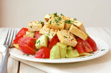 Sağlıklı vegan salata sebze, domates, salatalık, yeşil biber, soya peyniri, chives ve zeytinyağı üzerinden