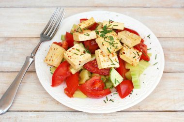 Sağlıklı vegan salata sebze, domates, salatalık, yeşil biber, soya peyniri, chives ve zeytinyağı üzerinden