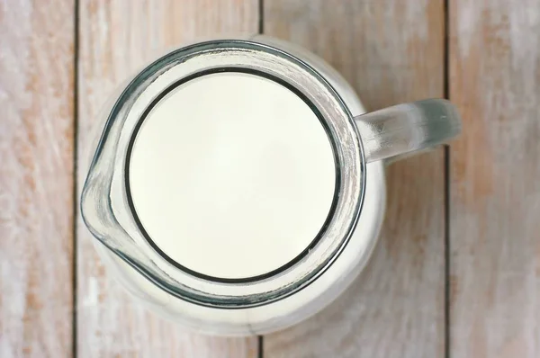 Weiße Milch die Kanne auf dem hölzernen Hintergrund — Stockfoto