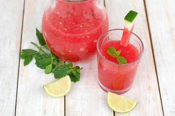 Healthy fresh smoothie drink from red watermelon, lime, mint and ice drift