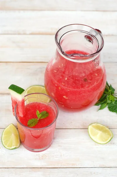 Healthy fresh smoothie drink from red watermelon, lime, mint and ice drift