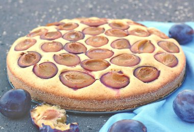 Parça ahşap zemin üzerine mavi kumaş üzerine Erik ile yaz pastası