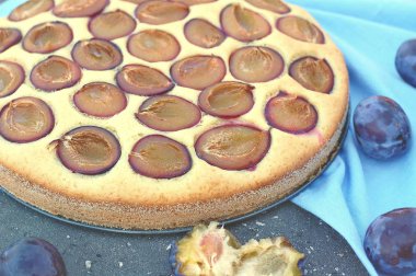 Parça ahşap zemin üzerine mavi kumaş üzerine Erik ile yaz pastası