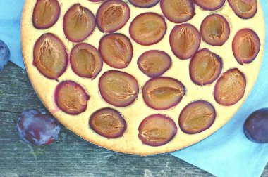 Parça ahşap zemin üzerine mavi kumaş üzerine Erik ile yaz pastası