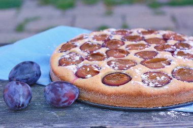 Parça ahşap zemin üzerine mavi kumaş üzerine Erik ile yaz pastası