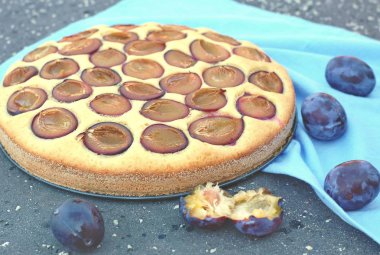 Parça ahşap zemin üzerine mavi kumaş üzerine Erik ile yaz pastası