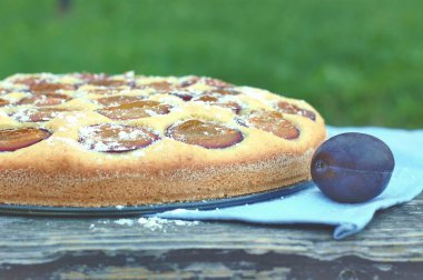 Parça ahşap zemin üzerine mavi kumaş üzerine Erik ile yaz pastası