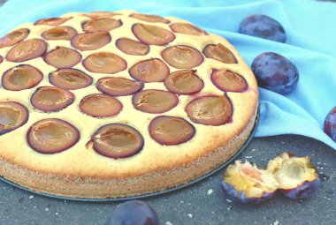 Parça ahşap zemin üzerine mavi kumaş üzerine Erik ile yaz pastası