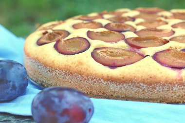 Parça ahşap zemin üzerine mavi kumaş üzerine Erik ile yaz pastası