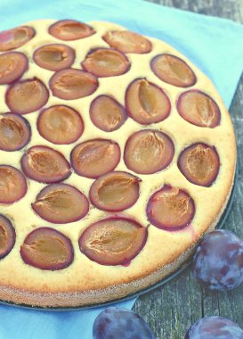 Parça ahşap zemin üzerine mavi kumaş üzerine Erik ile yaz pastası