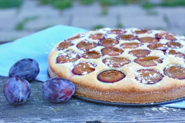 Parça ahşap zemin üzerine mavi kumaş üzerine Erik ile yaz pastası