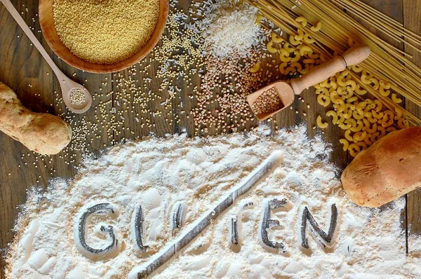 Cereais sem glúten milho, arroz, trigo sarraceno, quinoa, painço, macarrão e farinha com glúten de texto riscado sobre fundo de madeira marrom — Fotografia de Stock