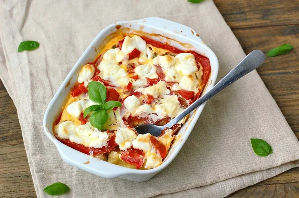 Comida sin gluten de harina de maíz tostada, tomate, queso de cabra y albahaca en un tazón blanco sobre tela sobre fondo de madera marrón —  Fotos de Stock