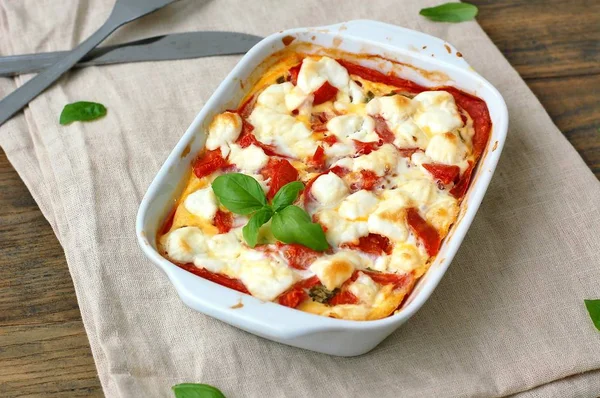 Comida sin gluten de harina de maíz tostada, tomate, queso de cabra y albahaca en un tazón blanco sobre tela sobre fondo de madera marrón —  Fotos de Stock