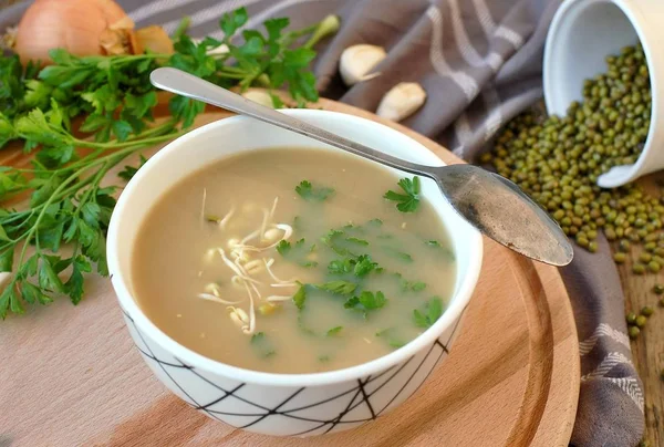 Wegańskie zdrowy zupa z fasoli mung, kolendry, czosnku i cebuli w misce na podłoże drewniane — Zdjęcie stockowe