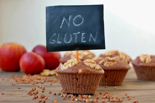 Muffins sem glúten de farinha de trigo mourisco, maçã, canela e nozes em fundo de madeira marrom com cartão de índice sem glúten — Fotografia de Stock