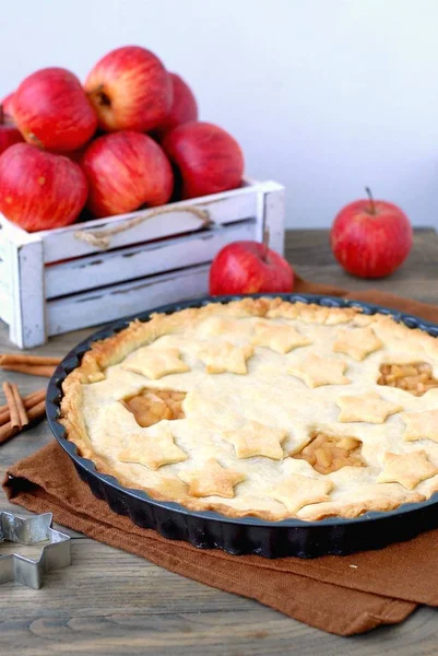 Tarte aux pommes américaine aux pommes rouges et cannelle sur fond bois foncé avec boîte blanche — Photo