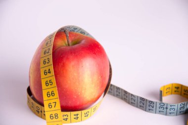 Beyaz bir arka plan üzerinde Apple ve dikiş teyp santimetre