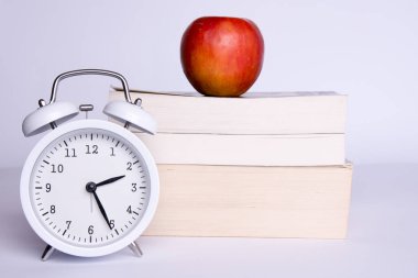 Apple, kitap ve beyaz zemin üzerine izle