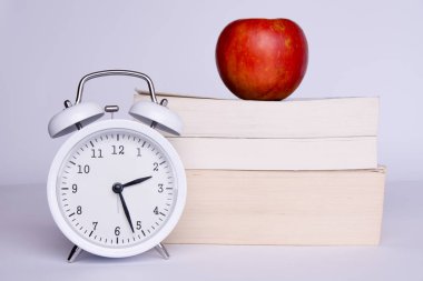 Apple, kitap ve beyaz zemin üzerine izle