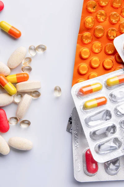Cheio de pílulas e cápsulas espalhadas em um fundo branco — Fotografia de Stock