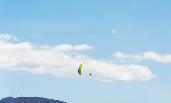 Paraplene dağlar ve mavi gökyüzü arka plan üzerinde uçuş — Stok fotoğraf