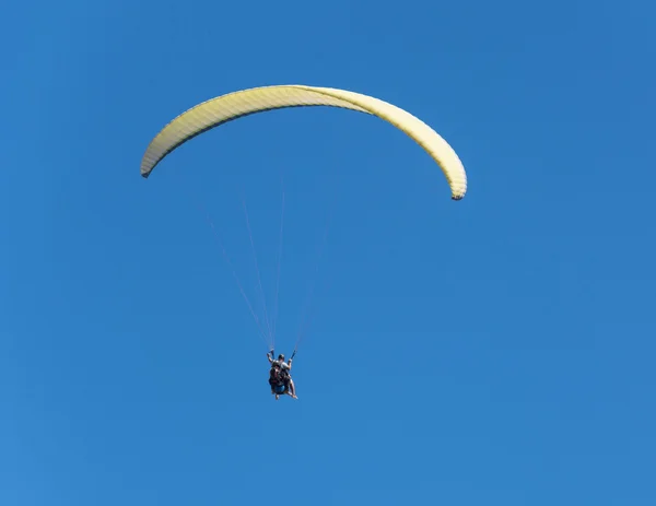 Volo verso il paraplene in tempo nuvoloso su uno sfondo blu — Foto Stock