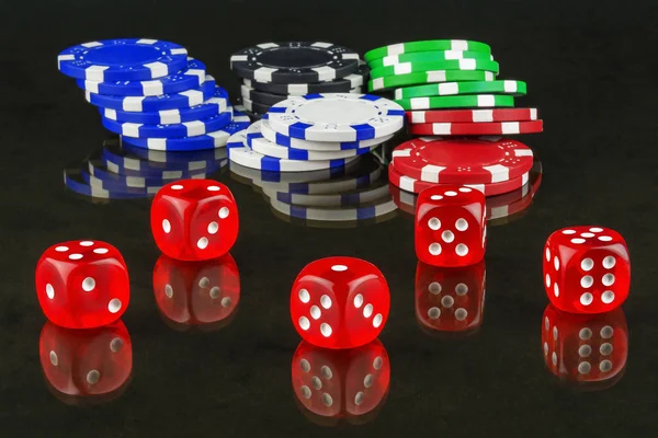 Op spiegelend oppervlak zijn casino chips en dobbelstenen voor het spelen pook — Stockfoto