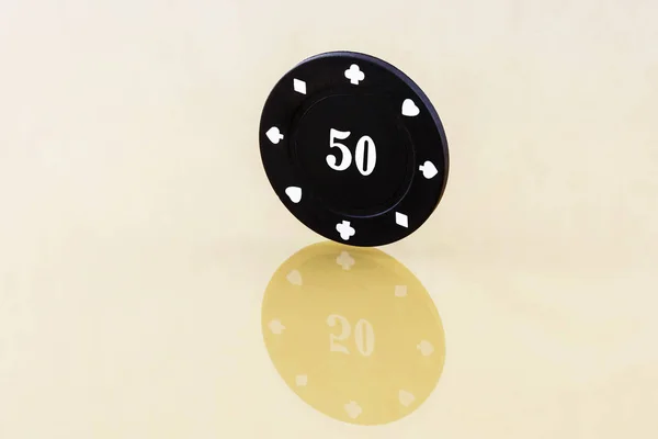Zwarte casino chips ter waarde van een rand op het reflecterende oppervlak — Stockfoto