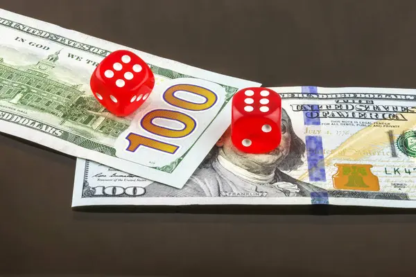 На банкнотах две красные кости покер — стоковое фото