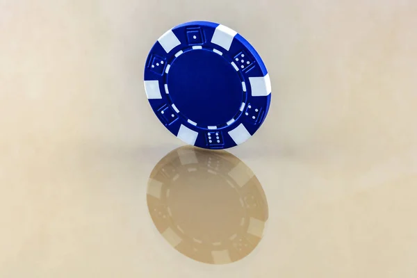 De blauwe casino chip staat op het spiegeloppervlak — Stockfoto