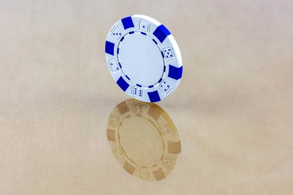 Een witte casino chip staat op het spiegeloppervlak — Stockfoto