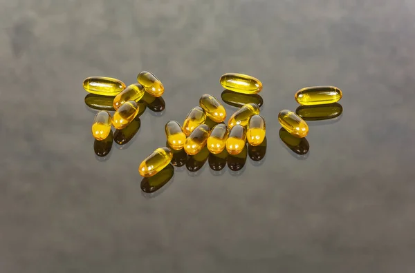 Na superfície de vidro encontram-se cápsulas com medicamento — Fotografia de Stock