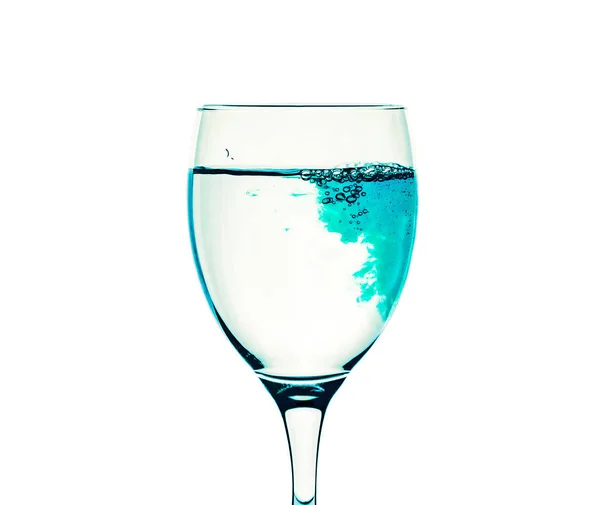 Um copo com água limpa é preenchido com líquido azul — Fotografia de Stock