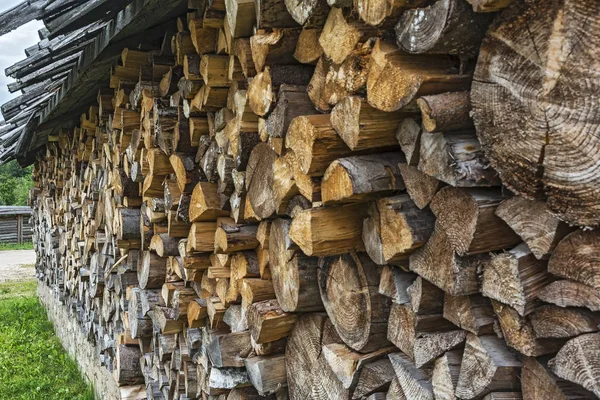 Le bois de chauffage haché est emballé dans un tas de bois sous un auvent — Photo