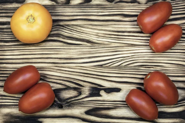 En la superficie de madera son tomates rojos y amarillos — Foto de Stock