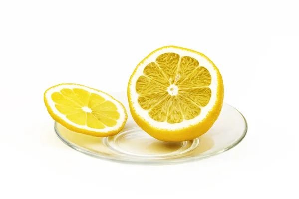 Op een glazen is schotel een schijfje citroen en een half gesneden citroen — Stockfoto