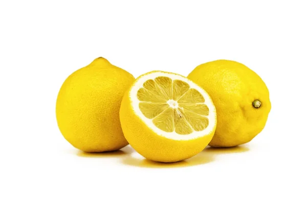 Dos limones amarillos enteros y una mitad cortada sobre un fondo blanco — Foto de Stock