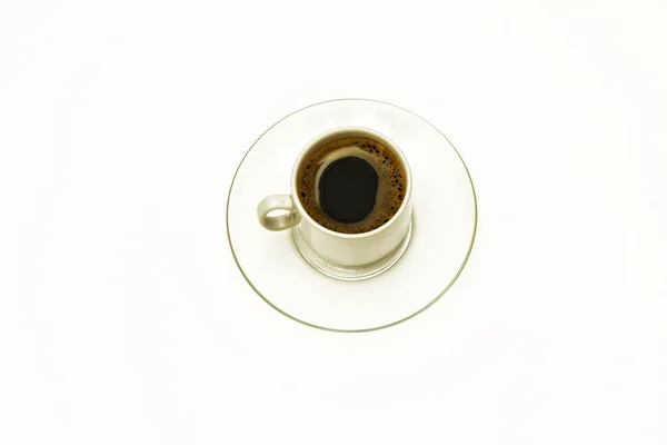 On a white background a cup of coffee on a transparent glass sau — Stock Photo, Image