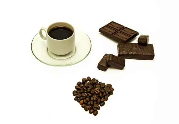 Chicchi di caffè, una tazza di caffè, cioccolato e cioccolato dolce — Foto Stock