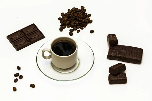 Grains of coffee, a cup of coffee with chocolate sweets and choc — Stock Photo, Image