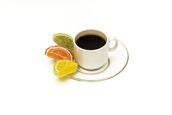 A cup of coffee and marmalade on a saucer on a white background — Stock Photo, Image