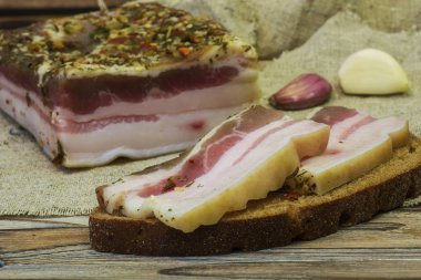 Masada iki siyah ekmek üzerinde tuzlanmış domuz eti dilim yalan