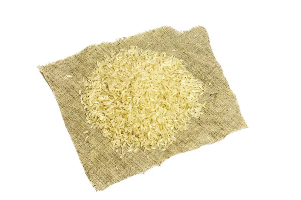 Una manciata di cereali di riso giace su un tovagliolo su uno sfondo bianco — Foto Stock