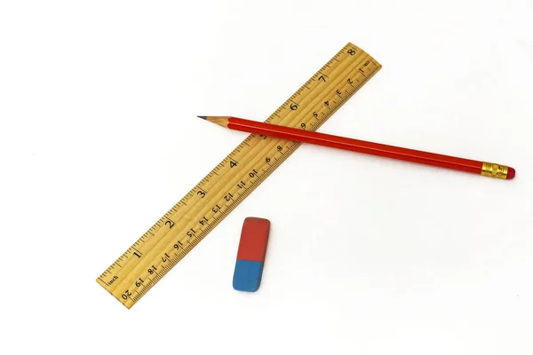Na białym tle leżą, linijki, gumki i prosty ołówek — Zdjęcie stockowe