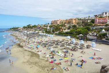 İnsanların rahatlamak ve Okyanusu yakınlarındaki Sahilde güneşlenmek
