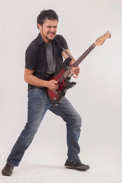 Young man jumping with electric guitar — Stock Photo, Image