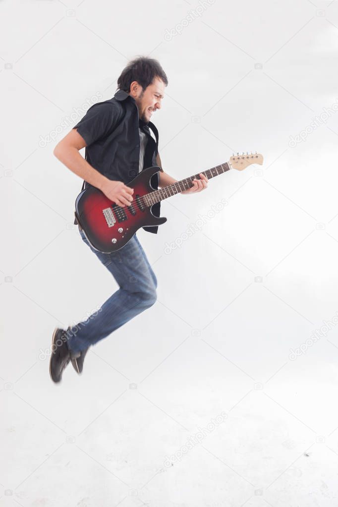 young man jumping with electric guitar