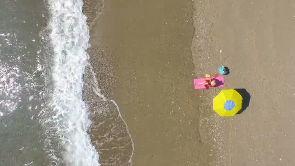 Antenne: Mooie jonge vrouw om te zonnebaden op het strand — Stockvideo