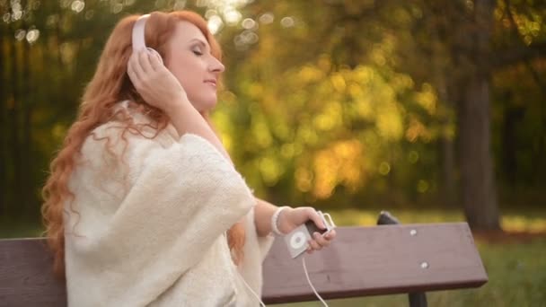 Hermosa mujer escuchando música en los auriculares — Vídeos de Stock